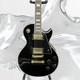 Guitare électrique Noire Lp Avec Des Accessoires En Or Et Un Corps En Acajou
