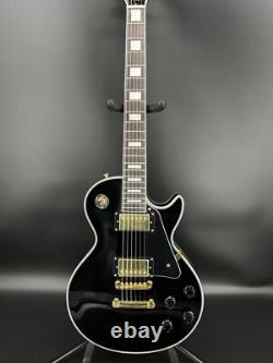 Guitare électrique noire LP avec des accessoires en or et un corps en acajou