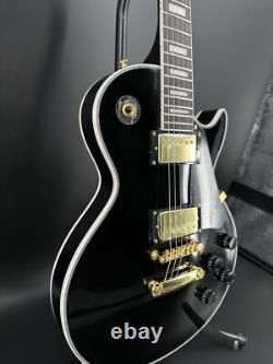 Guitare électrique noire LP avec des accessoires en or et un corps en acajou