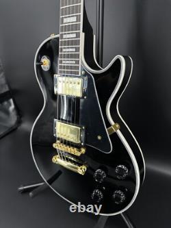Guitare électrique noire LP avec des accessoires en or et un corps en acajou