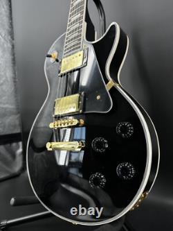 Guitare électrique noire LP avec des accessoires en or et un corps en acajou