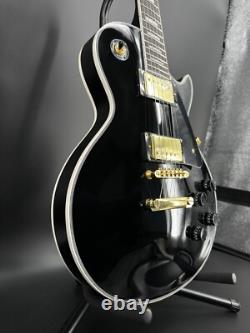 Guitare électrique noire LP avec des accessoires en or et un corps en acajou