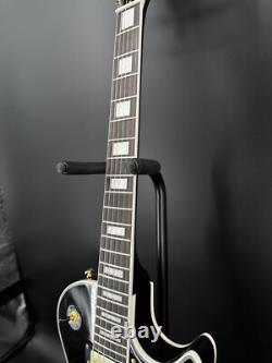 Guitare électrique noire LP avec des accessoires en or et un corps en acajou