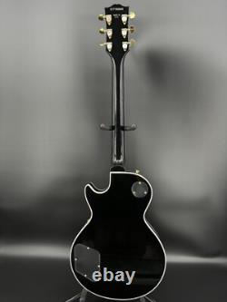 Guitare électrique noire LP avec des accessoires en or et un corps en acajou