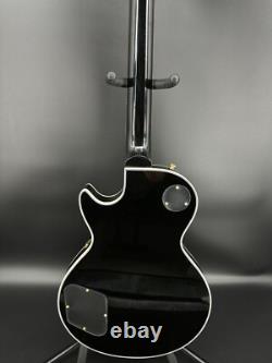 Guitare électrique noire LP avec des accessoires en or et un corps en acajou