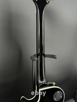 Guitare électrique noire LP avec des accessoires en or et un corps en acajou